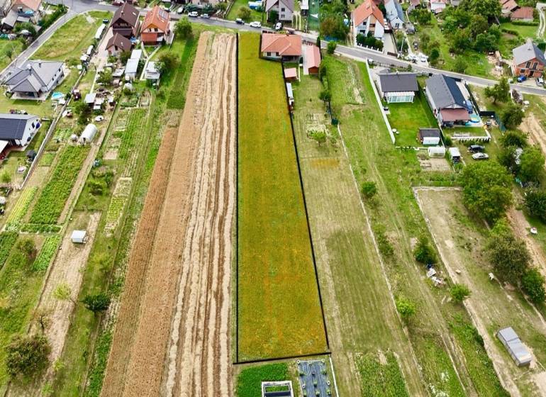 An aerial view shows residential plots in Trenčianske Jastrabie surrounded by houses and gardens.