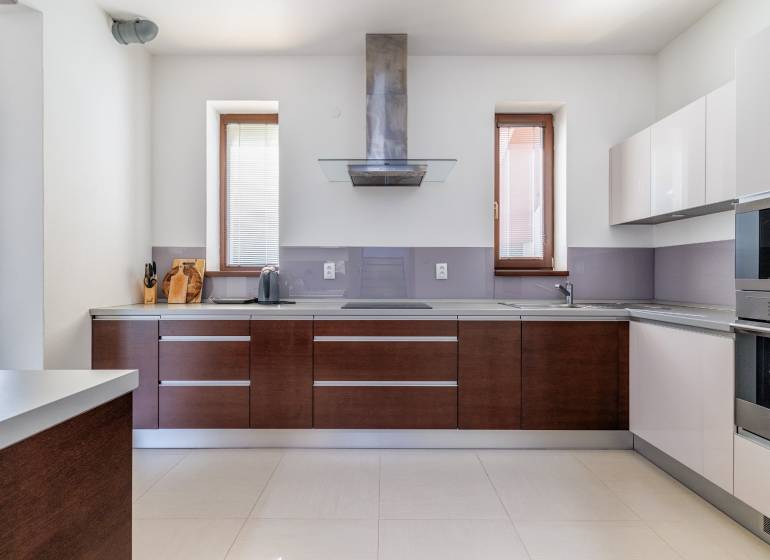 A kitchen in a family house with appliances and wooden cabinets.