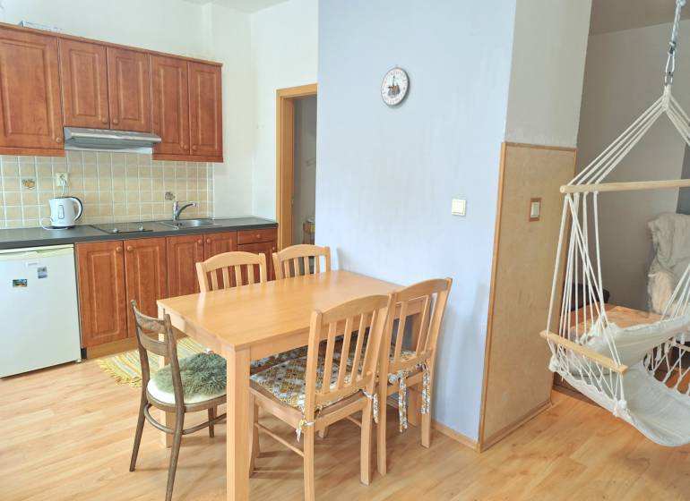 A kitchen with built-in cabinets, a dining table, and a rocking chair in a 3-room apartment.