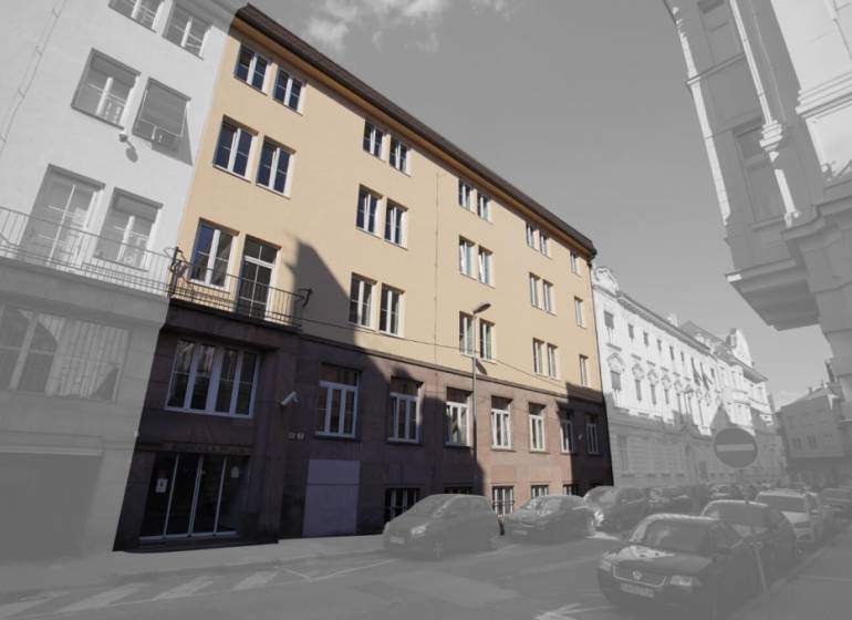 The building on Gunduličova Street in Bratislava - Old Town surrounded by cars in a row of buildings.