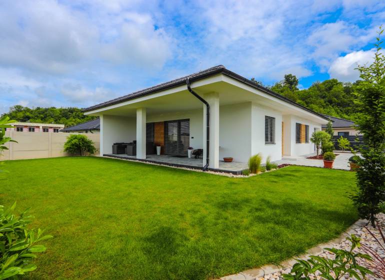 A family house in Piešťany with a glass terrace and a green lawn.