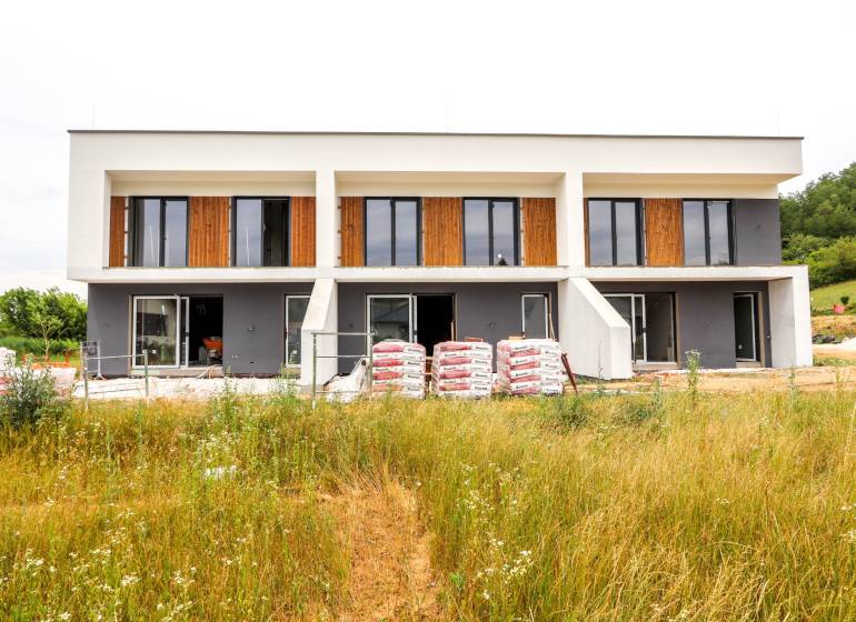 A family house in Piešťany with large windows, two floors, and an unfinished garden.
