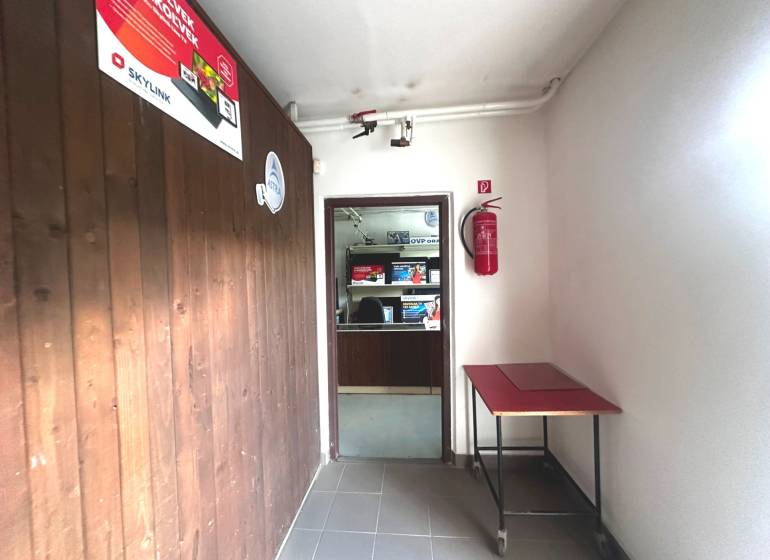 A corridor in commercial premises with wooden paneling and a fire extinguisher.