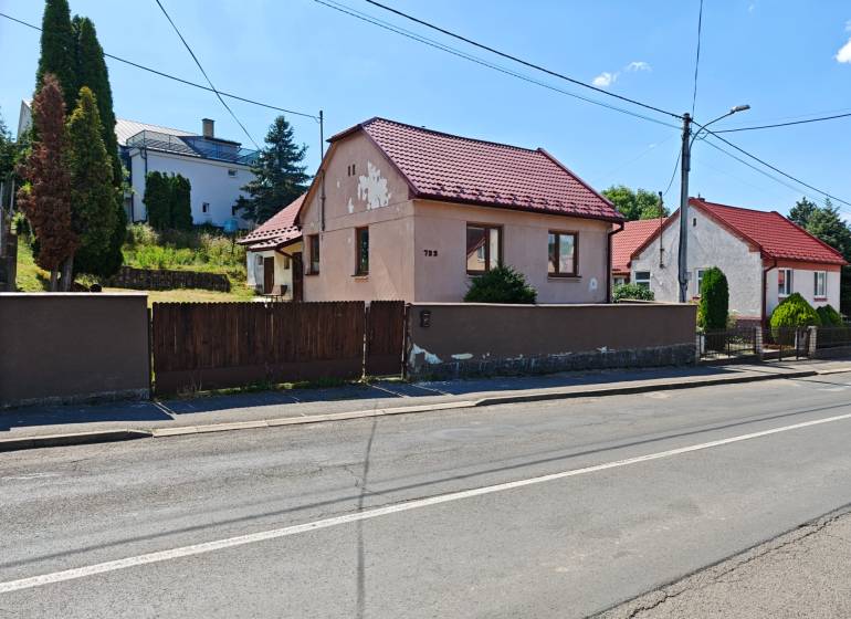 A family house on Dlhá Street in Vranov nad Topľou with a red roof and a wooden fence.