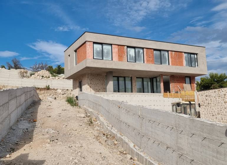 An unfinished villa in Vodice with a concrete terrace and modern windows.