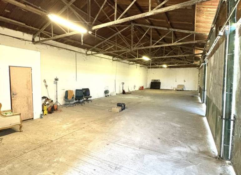 Interior of warehouses and halls with high wooden ceiling and concrete floor.