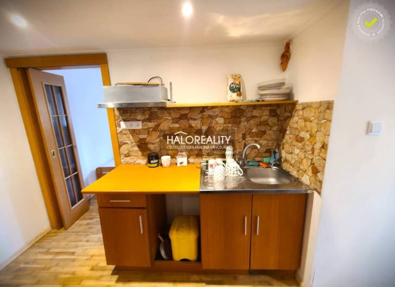 A kitchen in a family house with wooden furniture and stone cladding.