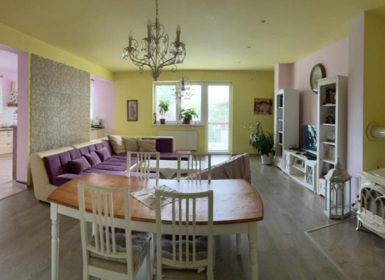 Living room with a dining area in a family house, a bright space with a fireplace.