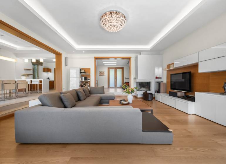 Living room in a family house with a large gray couch and white furniture.