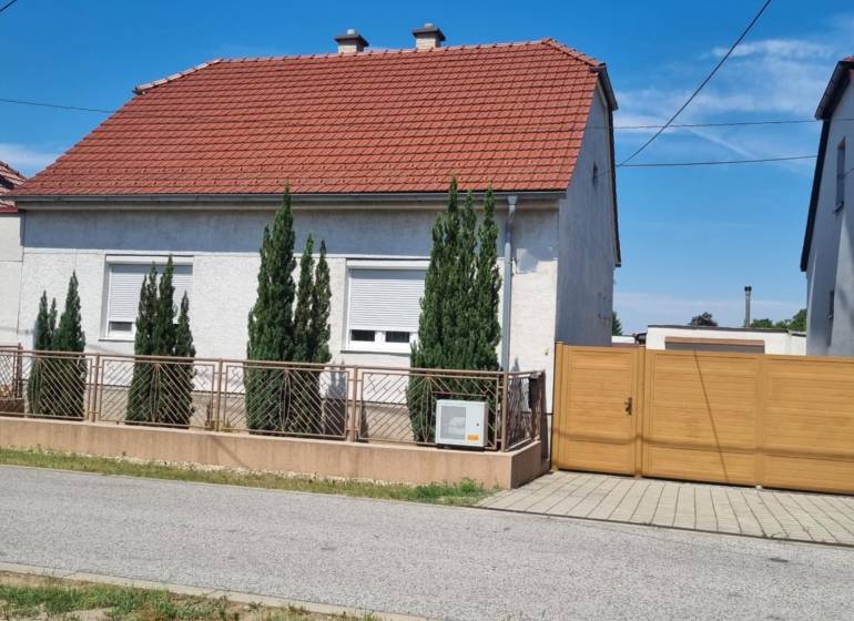 Family house on Písniky Street in Malacky, white facade, red roof, thuja trees by the fence.
