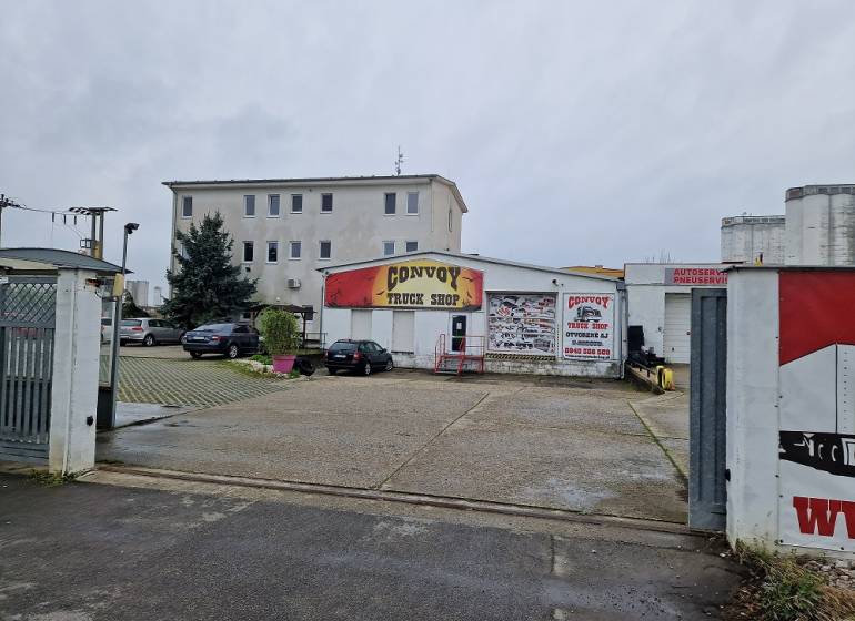 Convoy Truck Shop building on Šamorínska Street, surrounded by parked cars near the warehouse and halls.
