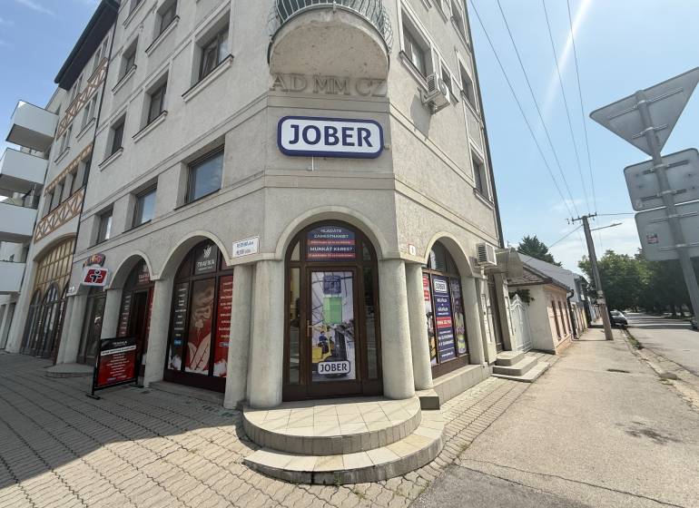 Commercial premises in Komárno on Petőfi Street with a sunny facade and advertising signs.