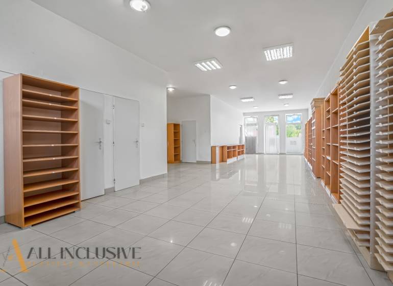 Interior of commercial premises with shelves and a well-lit entrance.