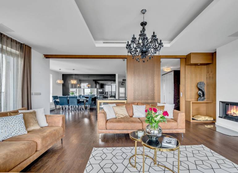 Elegant living room with a sofa, fireplace, and light fixture in a 4-room apartment.