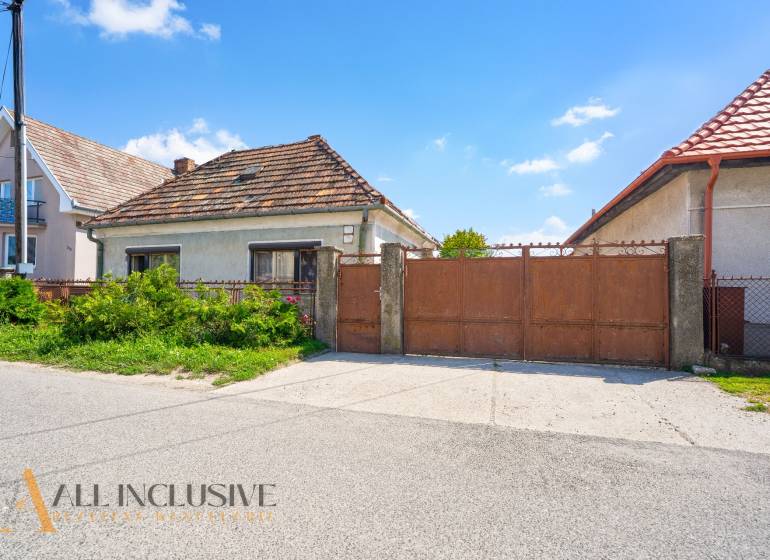A family house in Jahodná with a brown gate and a garden in front of the entrance.