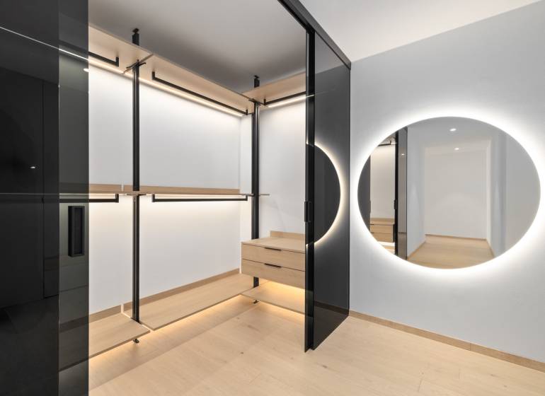 A wardrobe in a 2-room apartment with a mirror and wooden details.