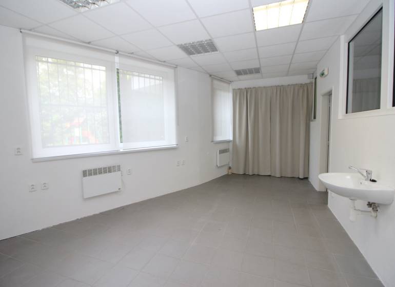 Spacious commercial premises with windows, a sink, and a curtain.