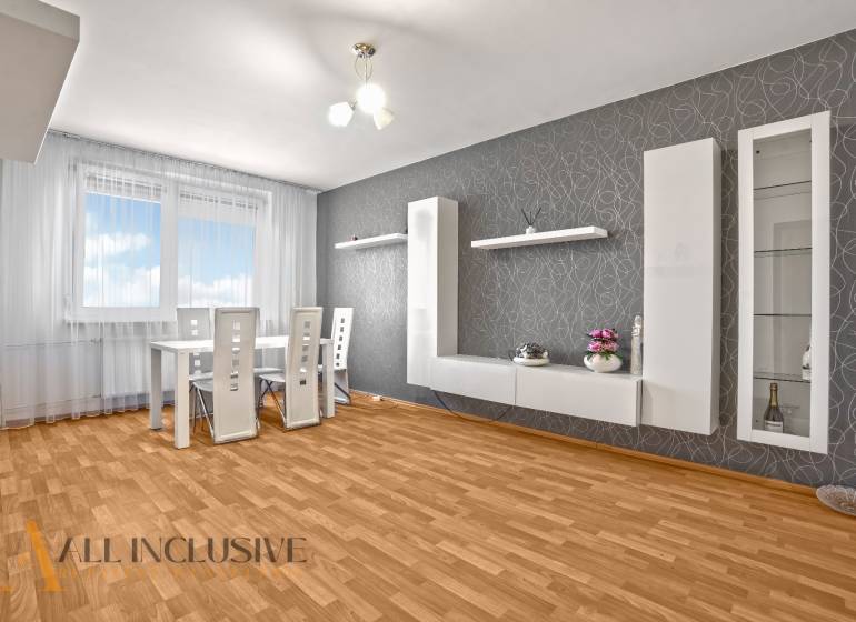 Dining area with a white table and chairs in a 2-room apartment.