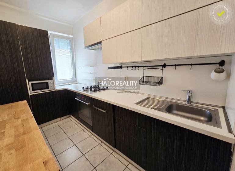A kitchen in a 3-room apartment with a wooden countertop and built-in appliances.