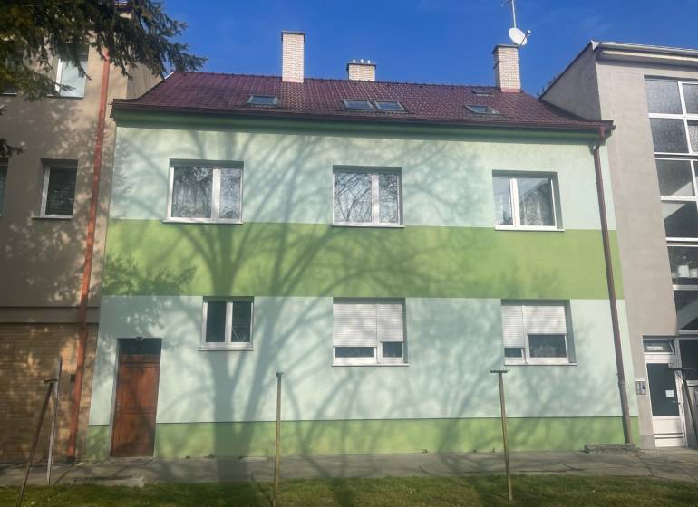 A family house on Kalinčiakova Street in Piešťany, green facade, shadow of a tree.