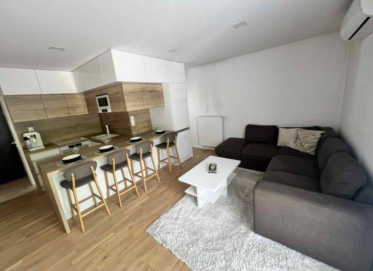 Living room in a 3-room apartment with a kitchen, bar counter, and corner sofa.