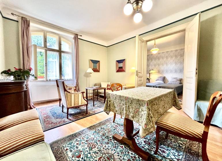 Traditional interior of a 2-room apartment with carpet, furniture, and houseplants.