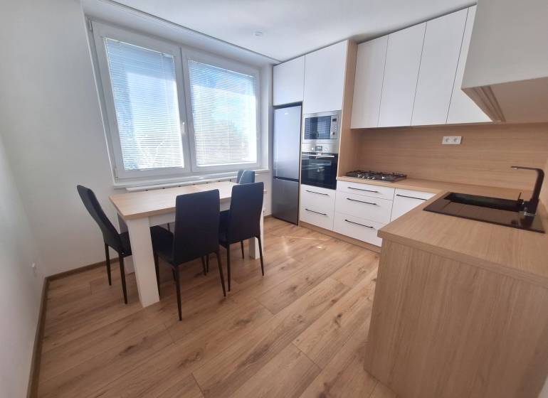 Kitchen in a 2-room apartment with a dining table, stove, and appliances.