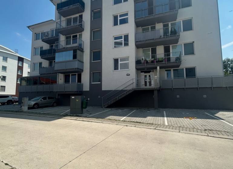 Five-story apartment building with a staircase and parking lot on Slavomírova Street in Slovenský Grob.