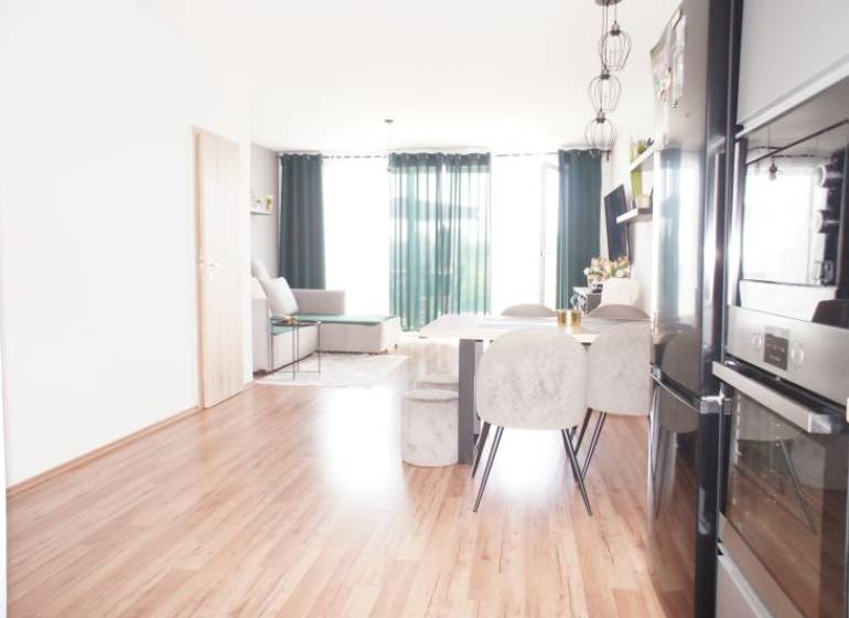Living room in a family house with a dining table and a kitchen unit.