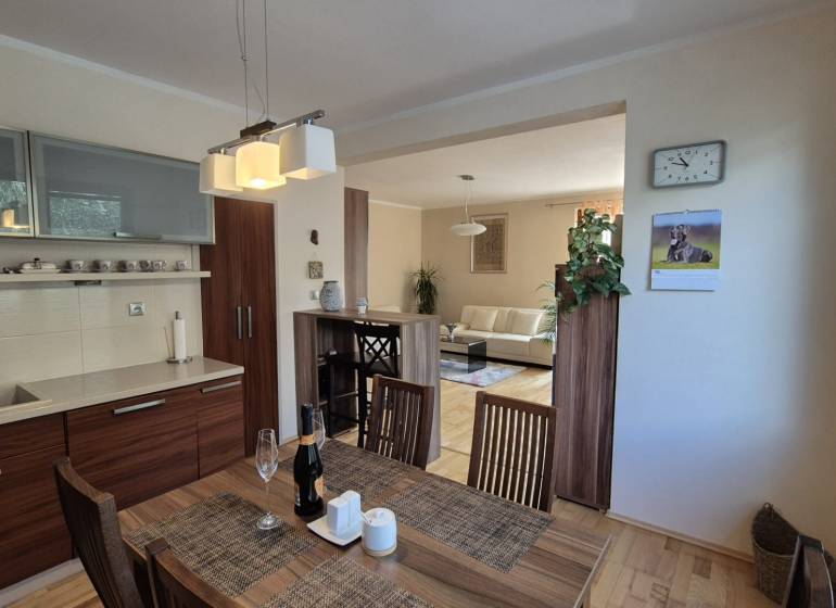Interior of a family house with a kitchen, dining table, and floor with wood decor.