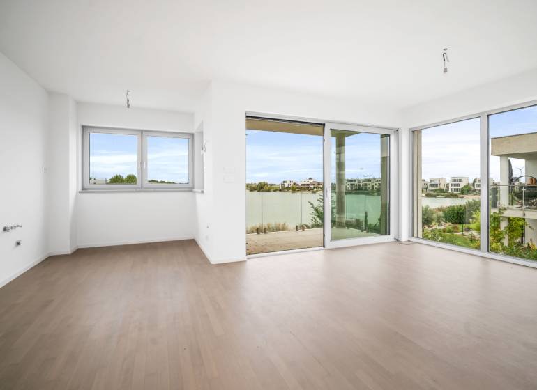 A bright room with a glass wall and a wooden decor floor in a four-room apartment.