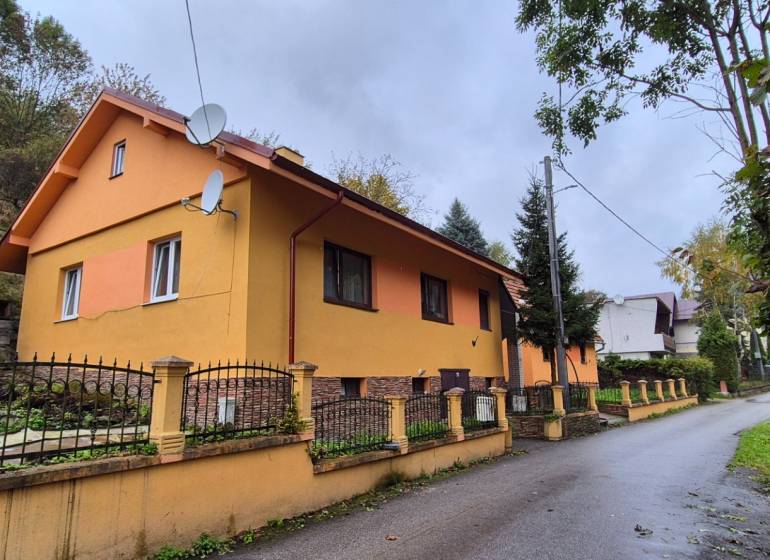 A family house on Škoruby in Kolárovice with a colorful facade and a small yard.