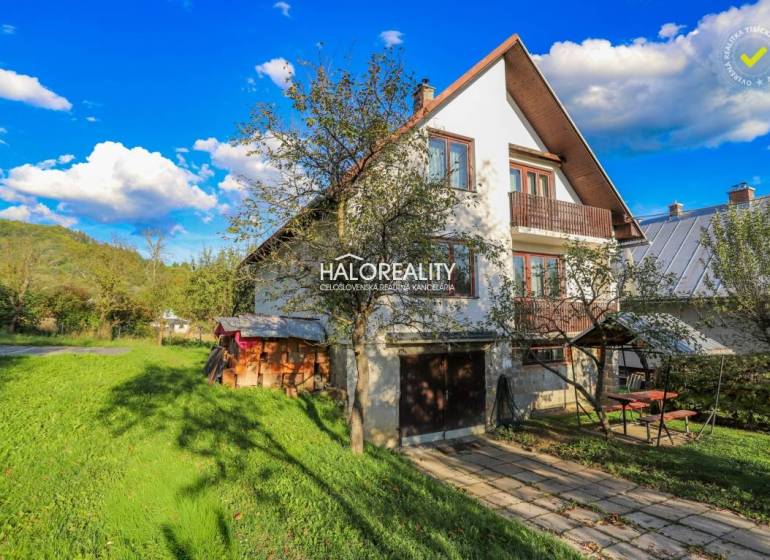 A family house in Papradno with a large garden, trees, and a wooden tool shed.