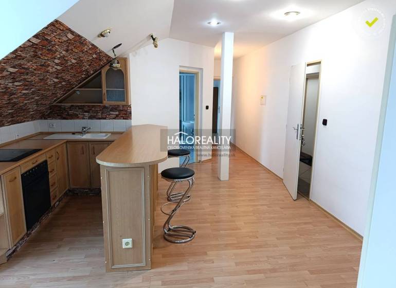 Interior of a 2-room apartment with a kitchenette and a wooden decor floor.