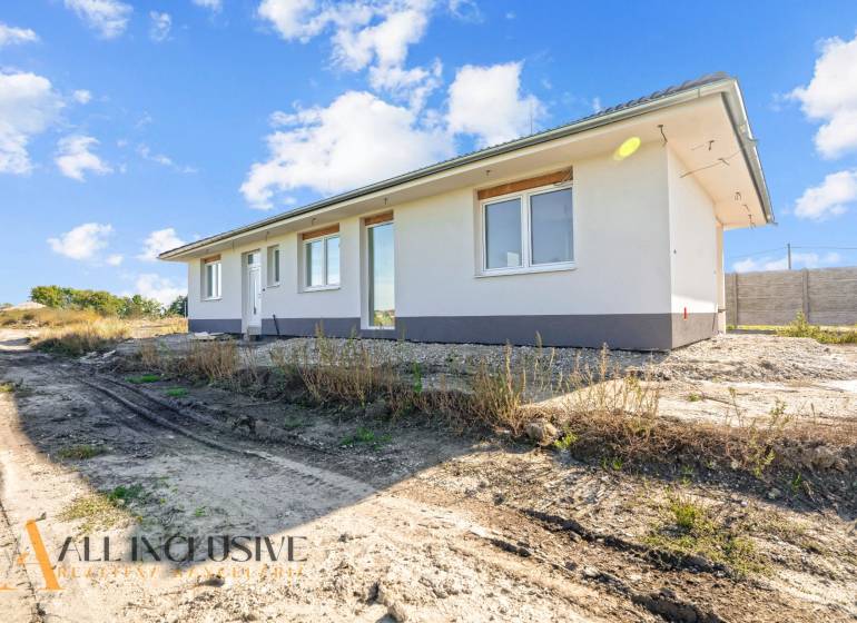 A family house in Gabčíkovo with a simple white facade surrounded by nature.