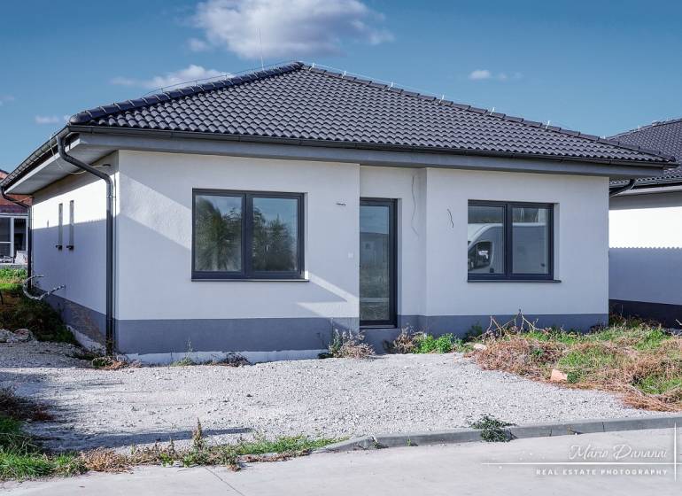 A family house in Slovenská Nová Ves on Slovenská Nová Ves street with a dark roof and parking lot.