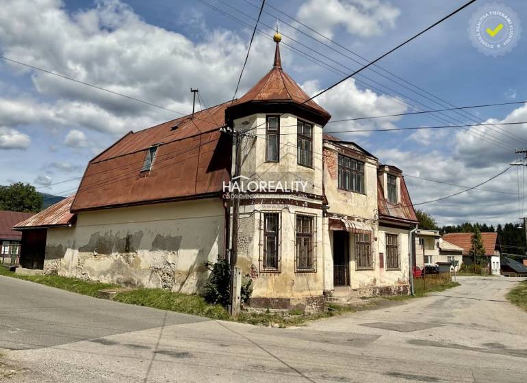 An older family house in Jasení, with a sloped metal roof on the corner of the street.