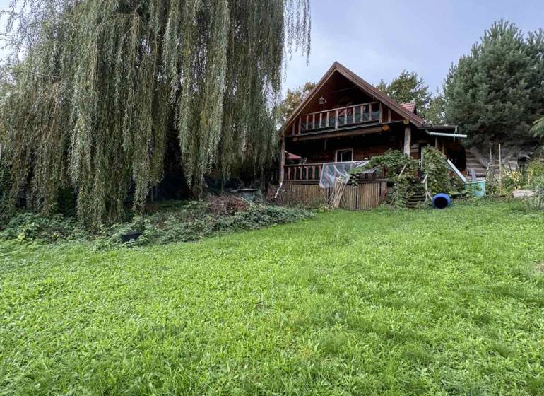 A cottage in Dolné Rykynčice with a spacious lawn and a majestic tree.
