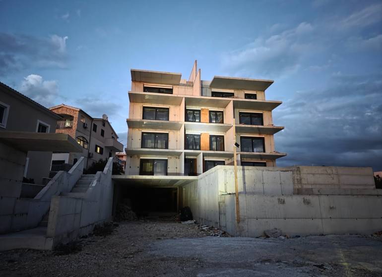 The exterior of a building in Primošten, suitable for a 3-room apartment, at dusk.