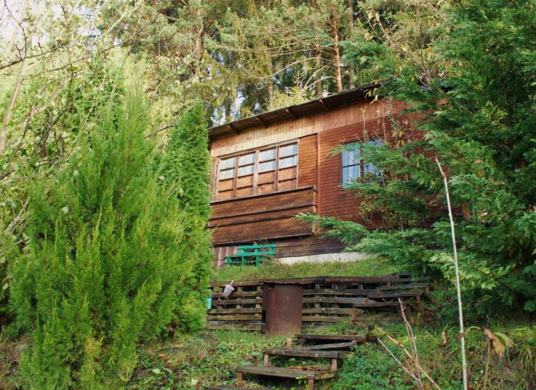 Wooden cottage surrounded by dense greenery in the Gardens on Budatínska Street in Žilina.