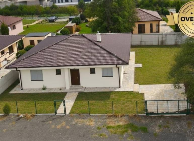 A family house in Studienka with a garden, a paved walkway, and a brown roof.