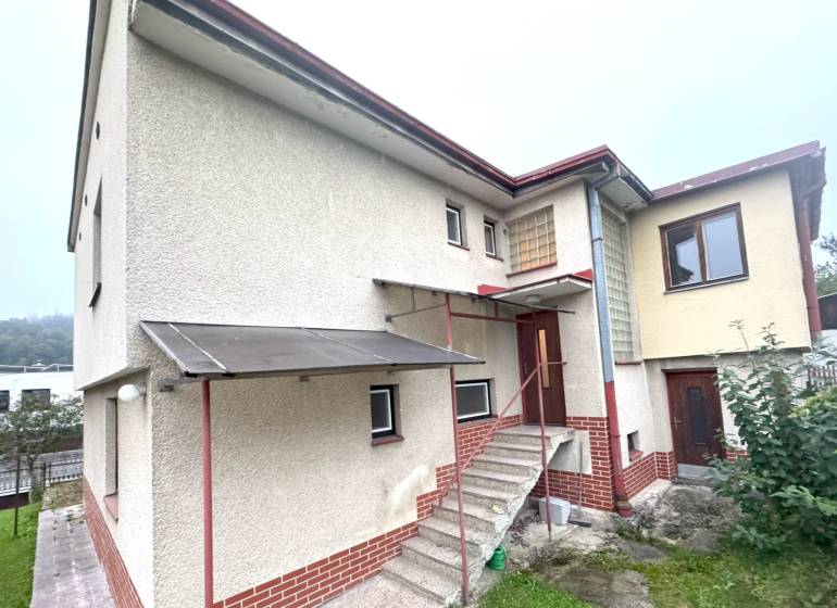 A family house in Tvrdošín with a floor and a staircase, greenery in front of the house.