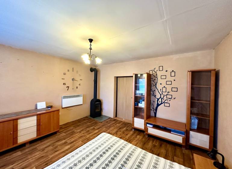 Family house with a fireplace, wooden furniture, and flooring with a wooden decor.