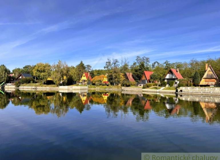 A cottage in Malé Leváre with a view of the lake and sky with reflections.