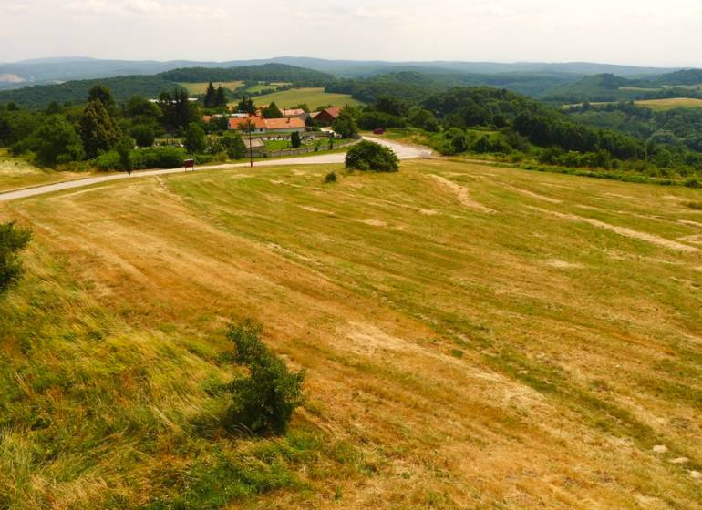 Agricultural and forest lands in Cerová with a visible village surrounded by green hills.