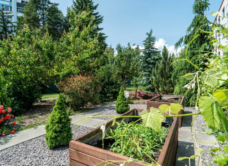 A garden with wooden planters and greenery on Janka Matúška Street in Bánovce nad Bebravou.