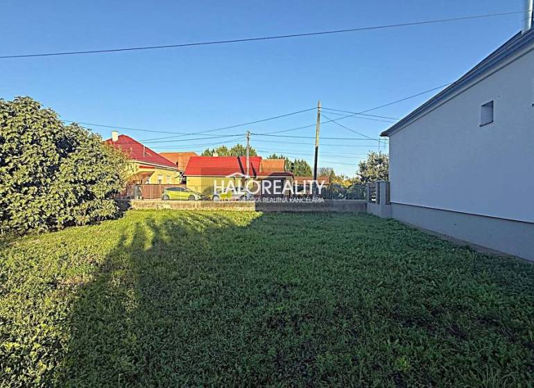 Plots - housing in Kameničná with grassy vegetation and surrounding development.