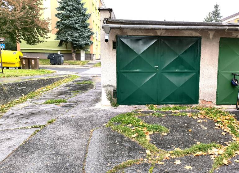 Garages on M. R. Štefánik Street in Detva with colorful containers and trees.