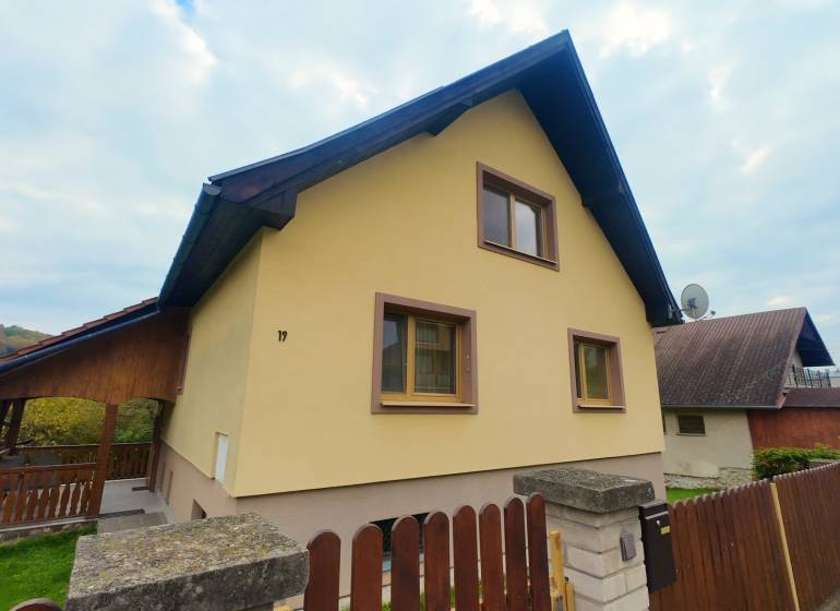 A family house in Medzev with a wooden terrace and stone fencing.