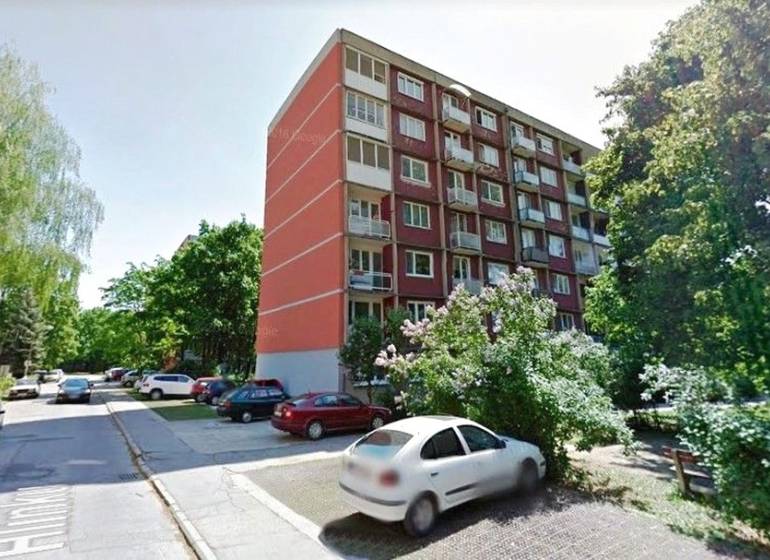 Apartment building on A. Hlinka Street in Piešťany, surrounded by greenery and parked cars.